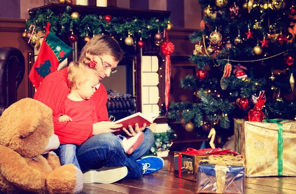 Πατέρας και κόρη ανάγνωση το βιβλιαράκι στα Χριστούγεννα — Φωτογραφία Αρχείου
