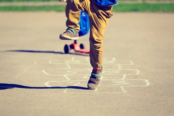 Pequeno menino jogar hopscotch no playground — Fotografia de Stock