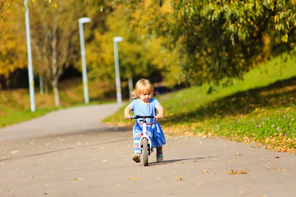 Carino bambina in sella runbike in autunno — Foto Stock