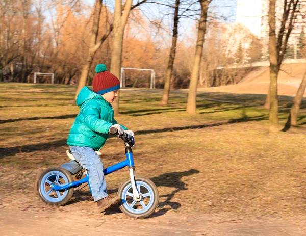 Маленький мальчик на велосипеде в осеннем парке — стоковое фото