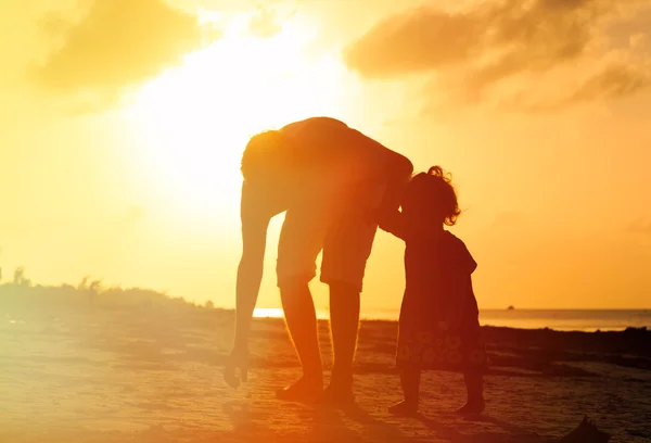 Πατέρας και μικρή κόρη περπατούν στην παραλία το ηλιοβασίλεμα — Φωτογραφία Αρχείου