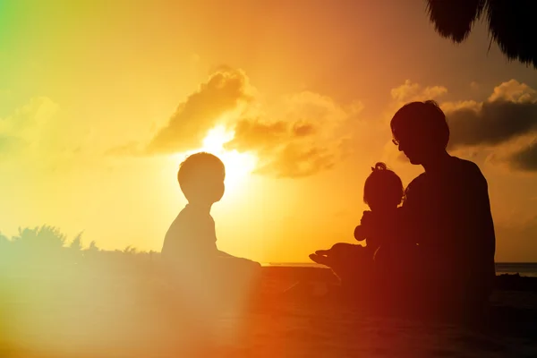 Pai com dois filhos, menino e menina, jogando ao pôr do sol — Fotografia de Stock