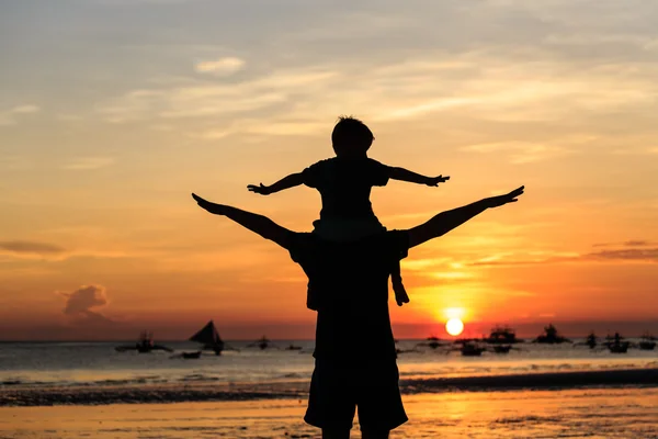 Famille heureuse sur la plage du coucher du soleil — Photo