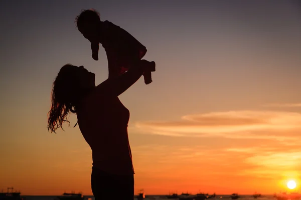 Moeder en baby in sunset beach — Stockfoto