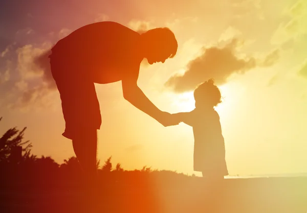 Padre e figlioletta si tengono per mano al tramonto — Foto Stock