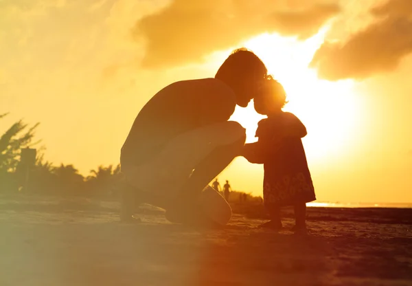 Pappa och lilla dotter silhuetter i solnedgången — Stockfoto
