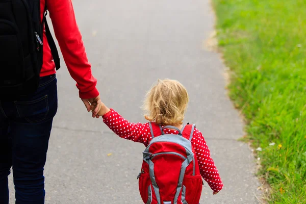 Modern som håller handen på lilla dotter med ryggsäck — Stockfoto