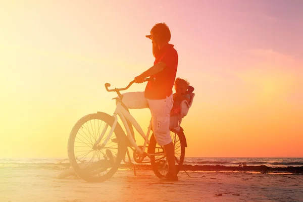 Silhouette of father and baby biking at sunset — Stock Photo, Image