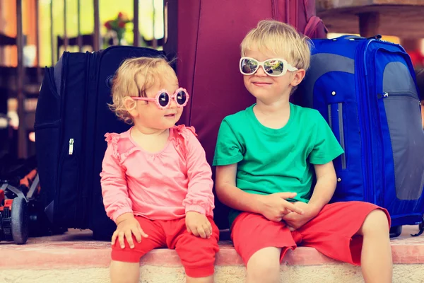 Little boy and toddler girl sitting on suitcases ready to travel — Stock Photo, Image