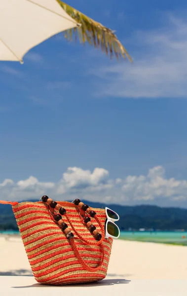 bag and sun glasses on tropical beach