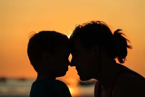 Mãe e filho na praia do pôr do sol — Fotografia de Stock