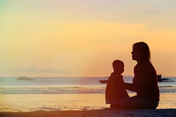 Madre e figlioletta sulla spiaggia al tramonto — Foto Stock