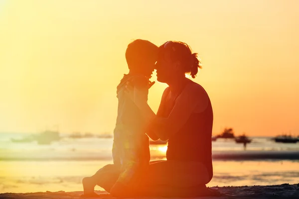 Madre e hijo en la playa del atardecer — Foto de Stock