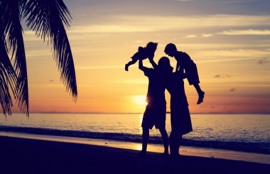 günbatımı plajda eğlenmek iki çocuklu mutlu aile