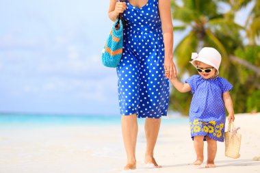 Anne ve sevimli küçük kız Sahilde yürüyüş