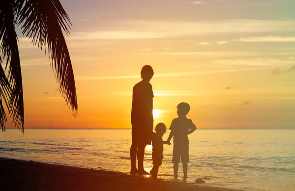 Padre e due bambini che camminano al tramonto — Foto Stock