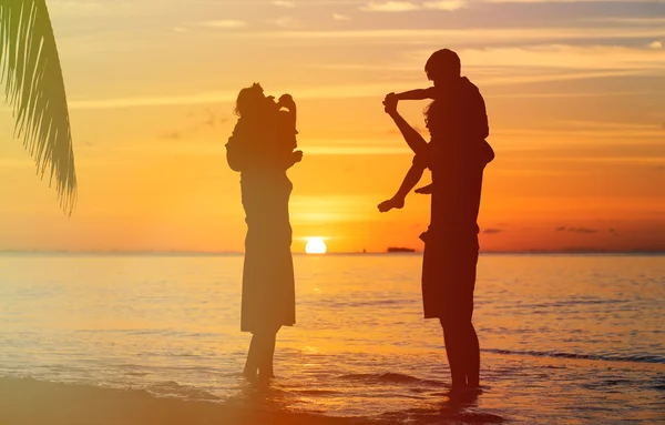 Lycklig familj med två barn har roligt på sunset beach — Stockfoto