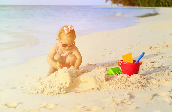 Linda niña jugando con arena en la playa — Foto de Stock
