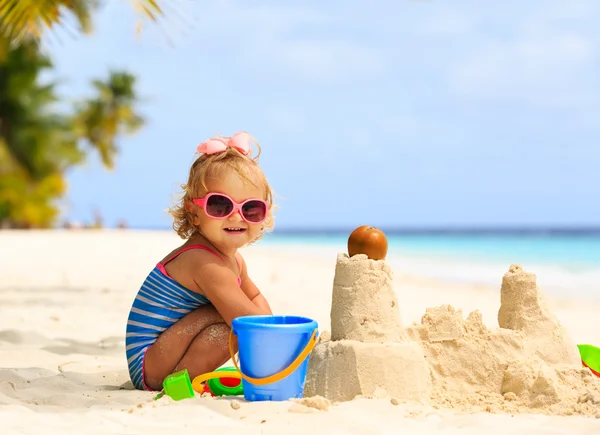 Linda niña jugando con arena en la playa —  Fotos de Stock