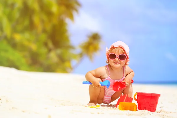 Το χαριτωμένο κοριτσάκι παίζει με την άμμο στην παραλία — Φωτογραφία Αρχείου