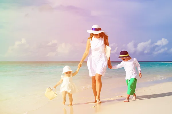 Moeder en twee kinderen lopen op tropisch strand — Stockfoto
