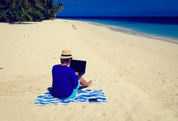 Mann mit Laptop am tropischen Strand — Stockfoto