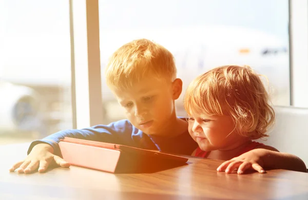 Niño y niña mirando almohadilla táctil en el aeropuerto —  Fotos de Stock