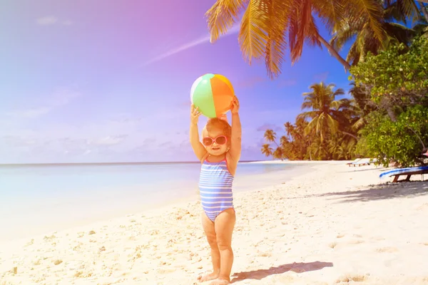 Sevimli küçük kız ile top oynarken sahilde — Stok fotoğraf