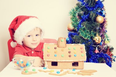 Noel babalar şapkalı gingerbread ev gülümseyen çocuk