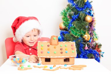 Noel babalar şapkalı gingerbread ev gülümseyen çocuk