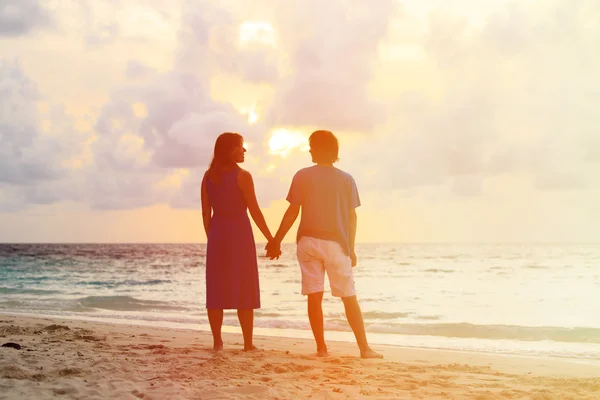 Jeune couple romantique sur la plage au coucher du soleil — Photo