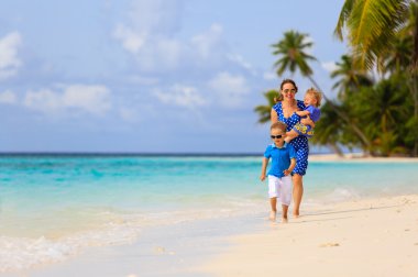 küçük çocuk annesi ve kız kardeşi yaz plaj üzerinde çalışan ile