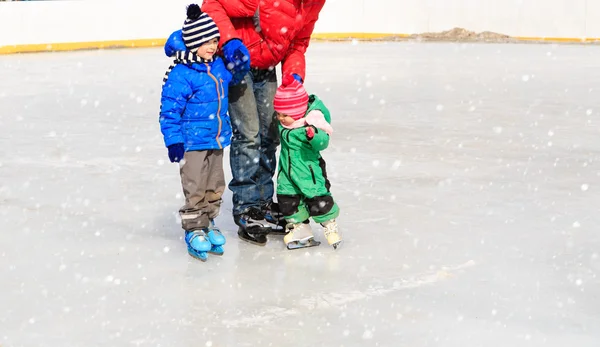 겨울에 스케이트 두 아이 들과 함께 아버지 — 스톡 사진