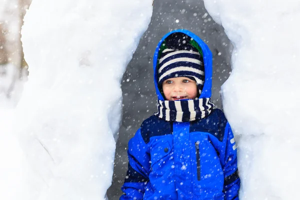 Kleine jongen plezier in winter sneeuw grot — Stockfoto