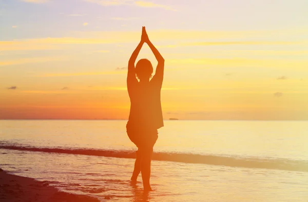 Silueta de hombre joven haciendo yoga al atardecer — Foto de Stock