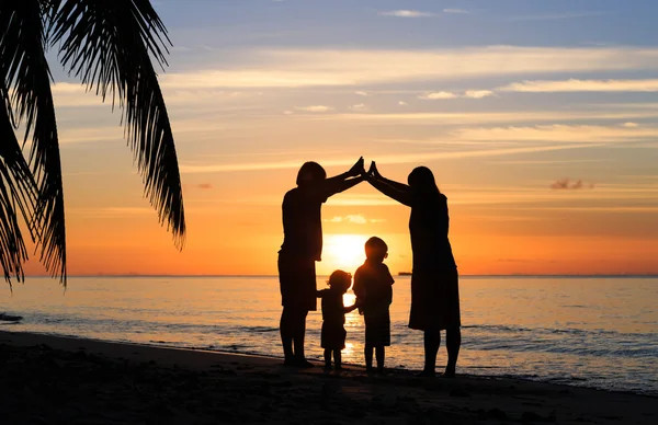 Šťastné mladé rodiče dělat doma pro děti při západu slunce — Stock fotografie