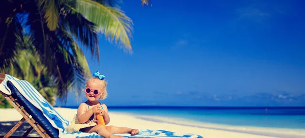 Linda niña con crema bloqueador solar en la playa tropical — Foto de Stock
