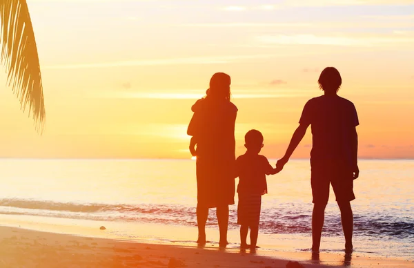 Família feliz com duas crianças na praia do por do sol — Fotografia de Stock