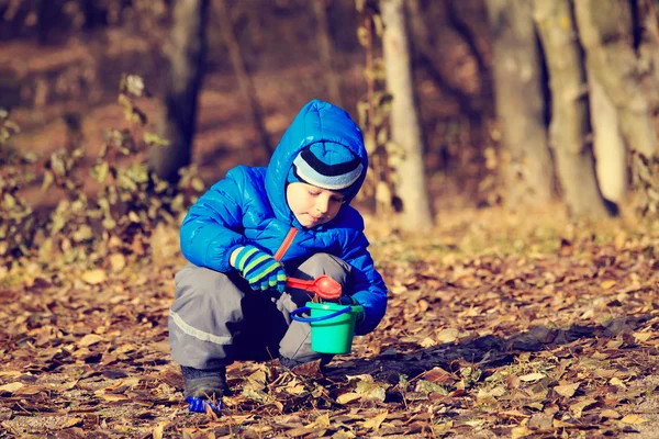 Menino brincando com brinquedos no parque de outono — Fotografia de Stock