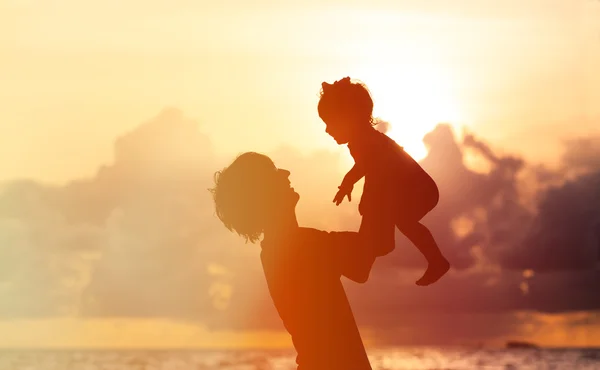 Baba ve küçük kızı siluetleri gün batımında — Stok fotoğraf