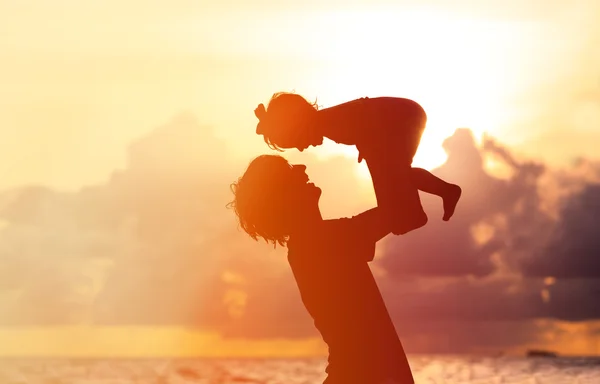 Pai e pequena filha silhuetas ao pôr do sol — Fotografia de Stock