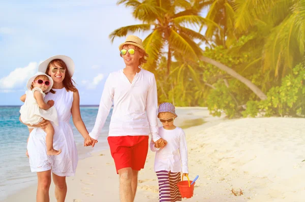 Jonge gezin met twee kinderen lopen op strand — Stockfoto