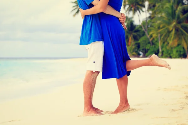 Pernas de beijar jovem casal na praia — Fotografia de Stock