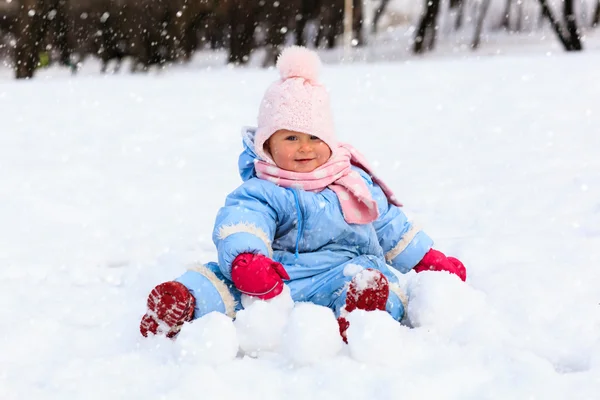 Klein meisje spelen met sneeuw in de winter — Stockfoto