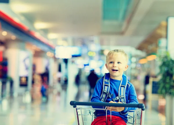 Söt liten pojke på flygplatsen ridning på bagage vagn — Stockfoto