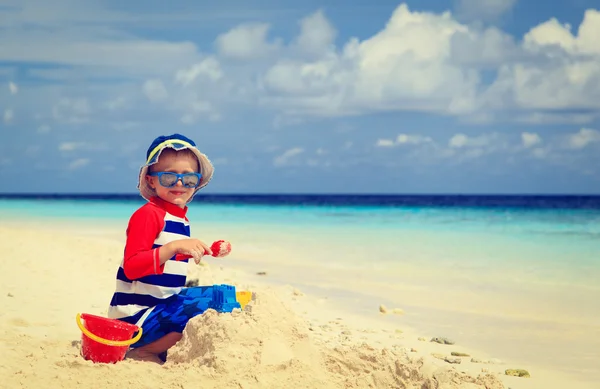 Kleine jongen gebouw sandcastle op tropisch strand — Stockfoto