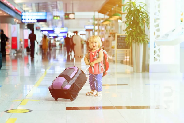 Liten flicka med resväska resor på flygplatsen — Stockfoto