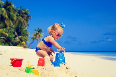 sevimli küçük kız sahilde kum ile oynamak
