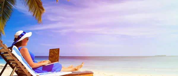 Junge Frau mit Laptop am tropischen Strand — Stockfoto