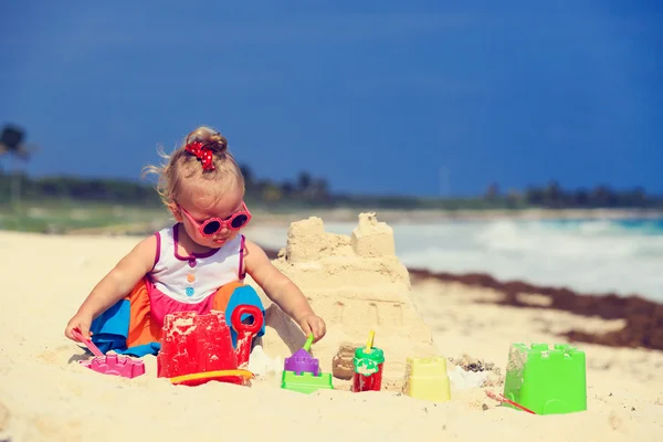 可爱的小女孩，建筑在沙滩上的堆沙堡 — 图库照片
